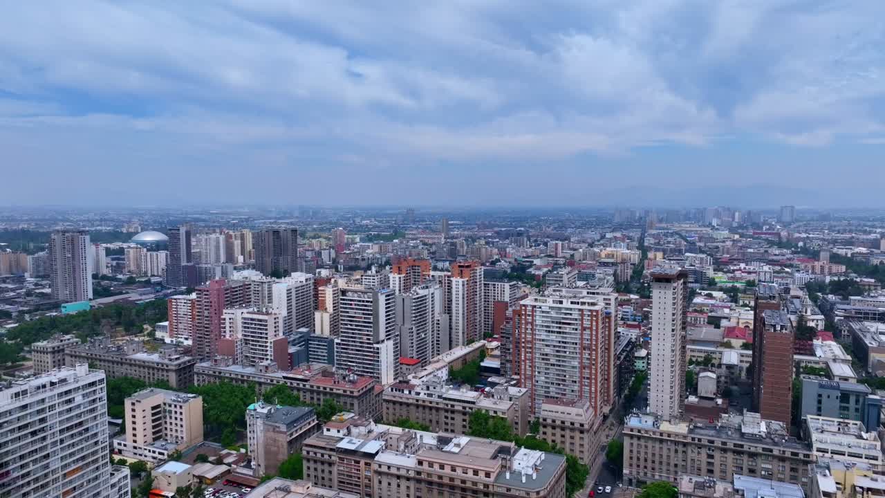 Descending Drone Shot Flying over Tall Residential Buildings in Santiago with Wide Urban View in the Background
