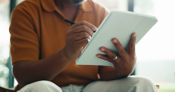 Person Using Digital Tablet and Stylus for Creative Work