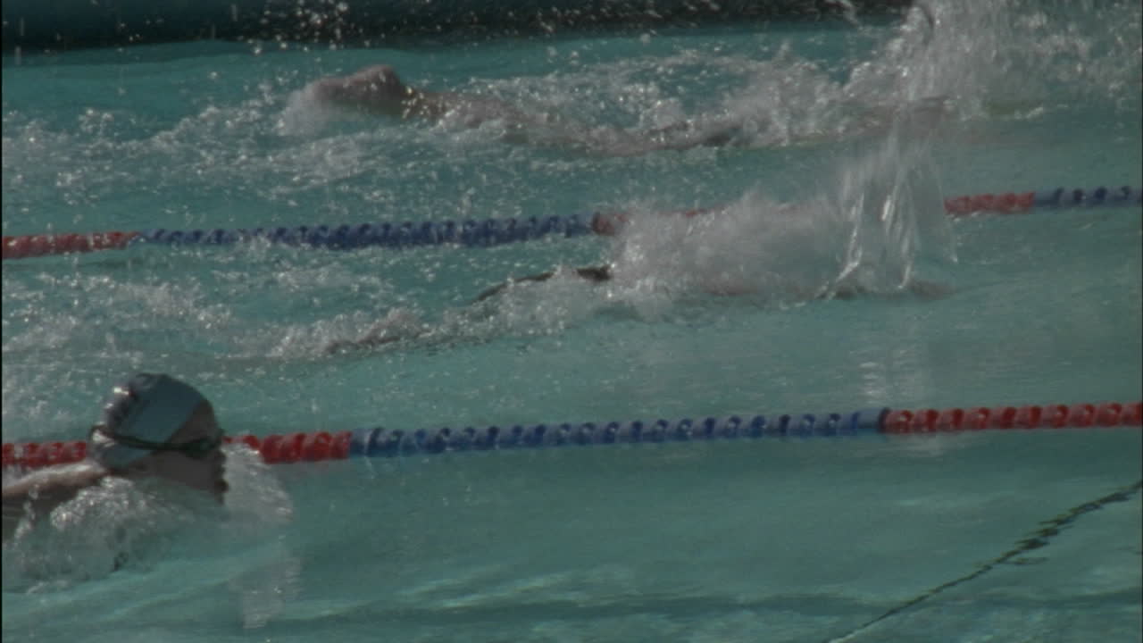 한 무리의 여성들이 수영장을 가로질러 헤엄을 치고 다시 시작합니다.