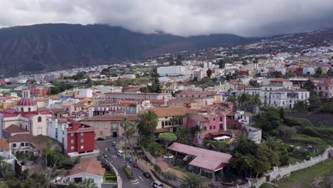 Drone-Revela-Pequeña-Ciudad-En-La-Isla-De-Tenerife-Puerto-De-La-Cruz-Islas-Canarias-España-Vista-Aérea-Del-Pintoresco-Pueblo-Con-Paisaje-Montañoso