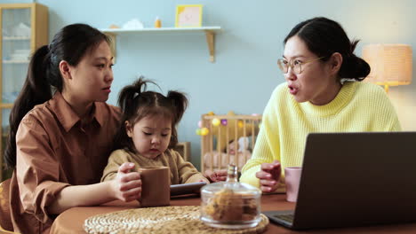 asian woman sitting at a table with her baby