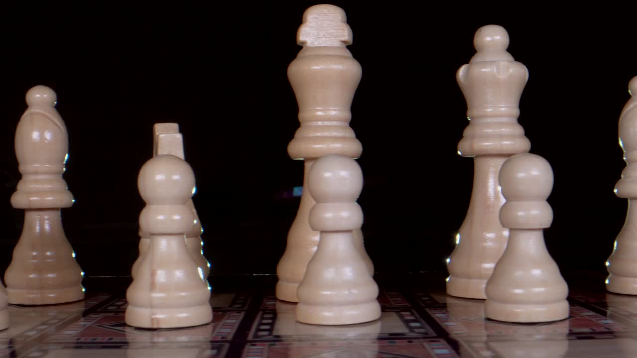 Trucking shot showing wooden chess figures with black background and backlit,close up
