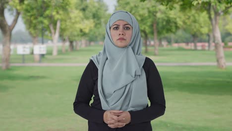 angry muslim woman looking at the camera in park