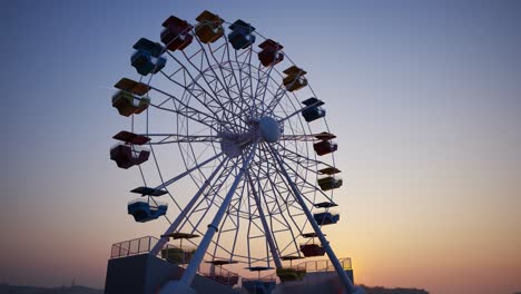 Colorful-Ferris-wheel-spinning-slowly-in-amusement-park-with-sky-in-the-background.-Ride-on-carousel-represents-entertainment-and-fun.-Endless,-seamless-loop.-Blue-sky-in-the-background.