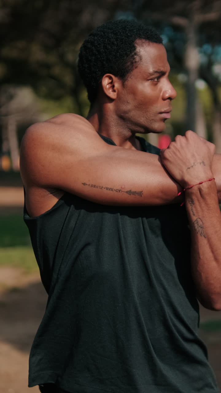 Fit Black Man Stretches in Park