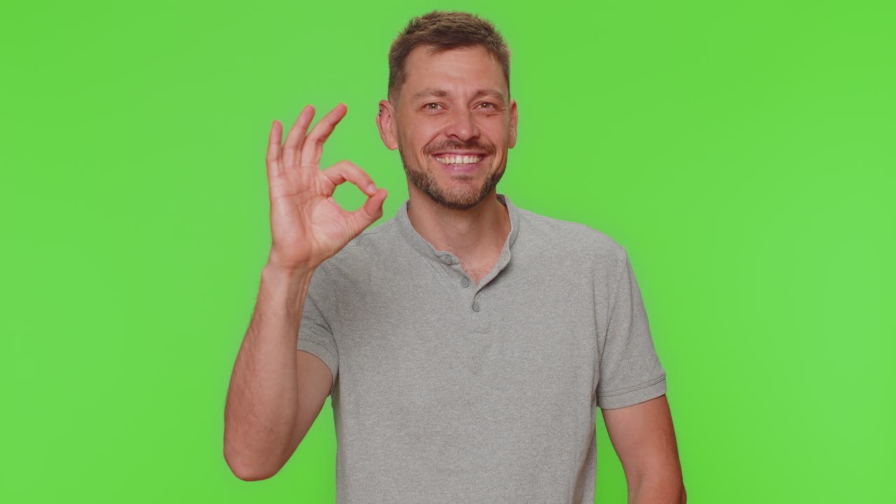 Bearded man guy looking approvingly at camera showing ok gesture, like sign positive, approve good