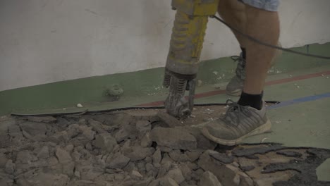 hombre con un martillo rompiendo un piso de hormigón