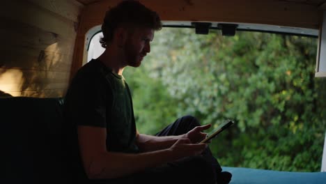 man using tablet inside van