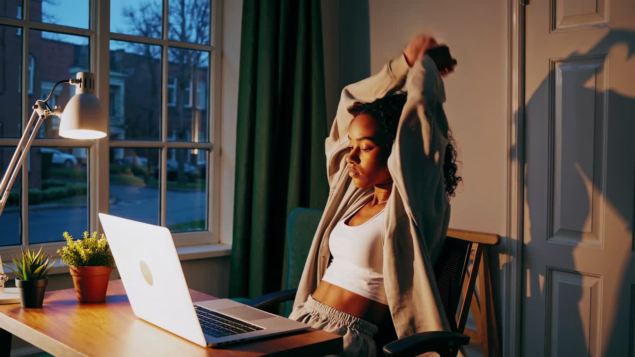 Woman Stretching While Working From Home at Night