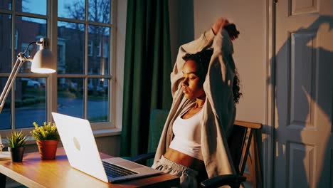 woman stretching while working from home at night