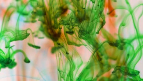 abstract footage of green ink droplets flowing in liquid