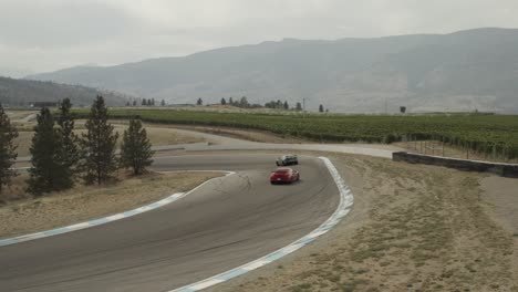 Back-view-of-Exotic-cars-driving-on-Osoyoos-race-track,-Area-27-Luxury-Motorsports-Club,-Canada