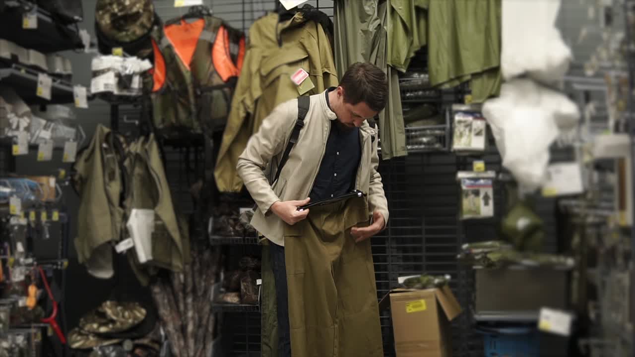 스포츠 용품 가게 에서 사냥 바지를 입으려고 하는 남자