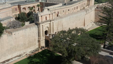 drone aerial shot of the main gate, bridge and fortification walls of the medieval city of mdina, malta