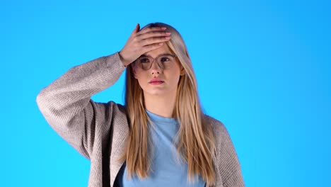 sick caucasian woman checks temperature on forehead with hand, self diagnose