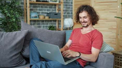 hombre trabajando en una computadora portátil en casa