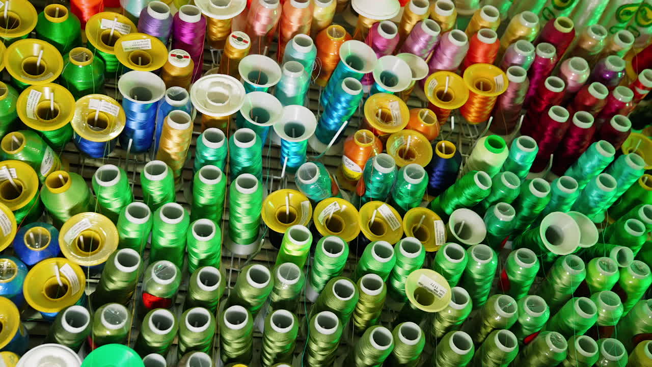 Background of colorful spools.Rows spools of thread of different colors for the sewing machine. Bright colors of threads on the table.