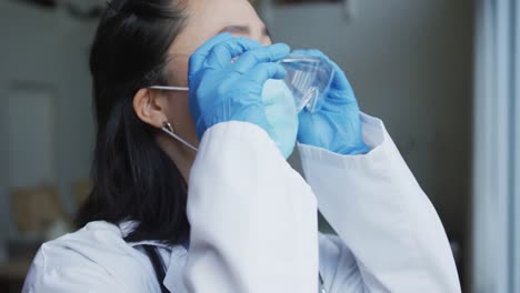 enfermera asiática con máscara facial que se pone gafas de seguridad protectoras en el hospital