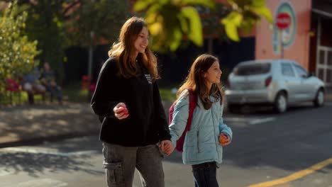 young girls walking hand-in-hand with apples outdoors