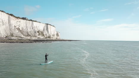 young man stand up paddle boarding in the sea