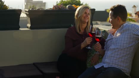 happy couple having red wine in the balcony at home 4k