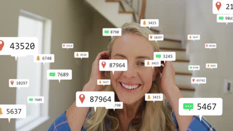 animation of social media icons and numbers over caucasian woman at home