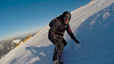 front view of a snowboarder going down at high speed with a selfie stick and nearly falling