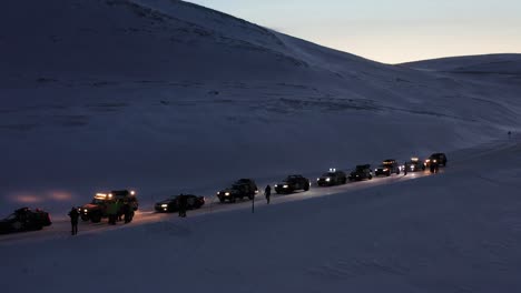 A-convoy-of-cars-preparing-to-go-towards-the-most-Northern-part-of-Europe,-the-Nordkapp,-during-a-cold-and-dark-winter-day