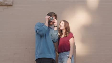 man takes photos with girl standing next to him in the sunlight