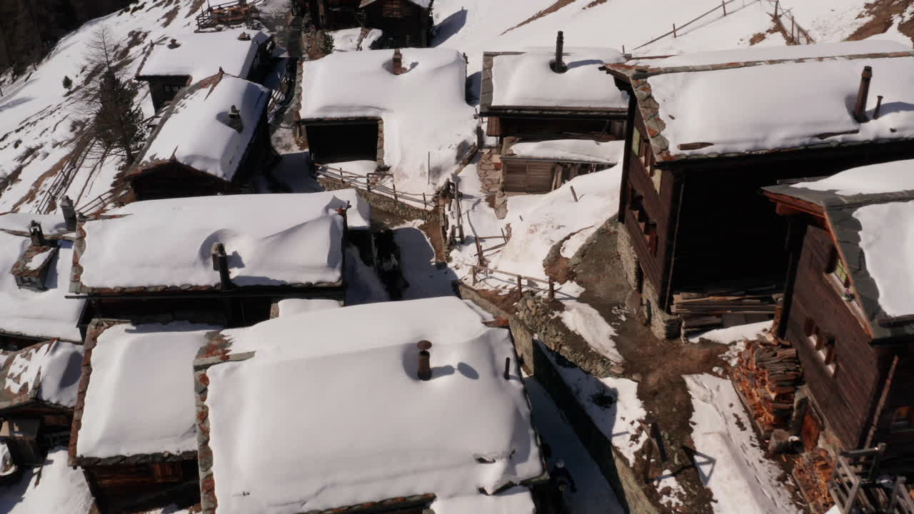 Aerial of people walking through small snow covered village in Switzerland