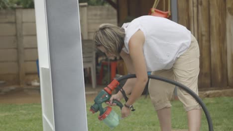 slow motion of woman using a spray gun