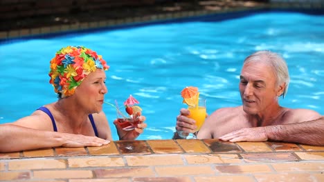 feliz pareja de edad brindando con cócteles