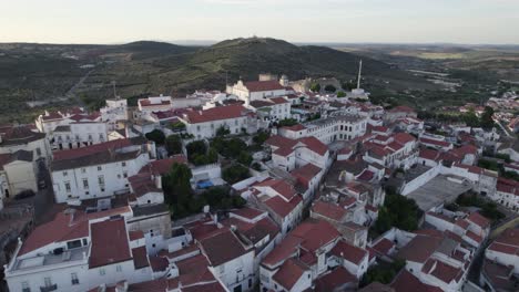 aéreo volando sobre los tejados de la ciudad de elvas para revelar el castillo en la cima de la colina