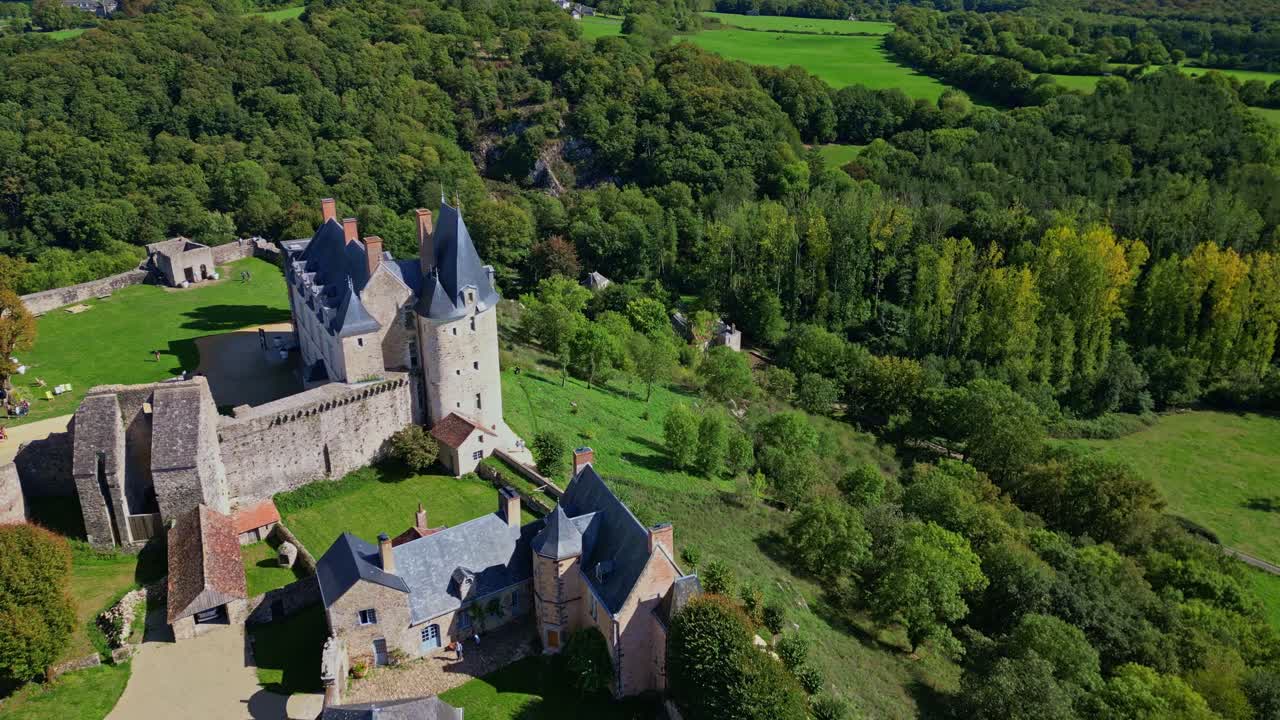 Château de Sainte-Suzanne, medieval castle and lush green landscape in Mayenne, France. Aerial drone panoramic view