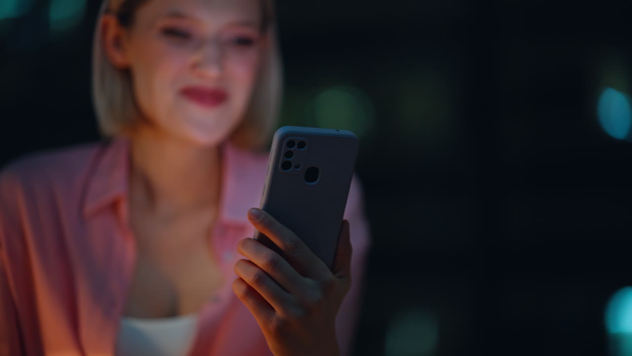 Donna che usa lo smartphone di notte