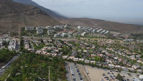 urban sprawl extends into the valley, showcasing a mix of residential homes and apartment buildings against a mountainous backdrop