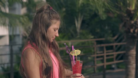 chica de pie con bebida y ondas de cabello en el viento en un día caluroso