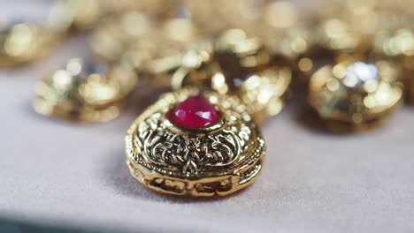 close-up of a gold necklace pendant with red gemstone