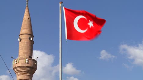 una bandera turca ondea cerca de una mezquita