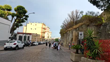 tourists walking down a cobblestone street in naples