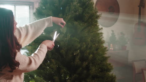 woman trimming a christmas tree for the holidays