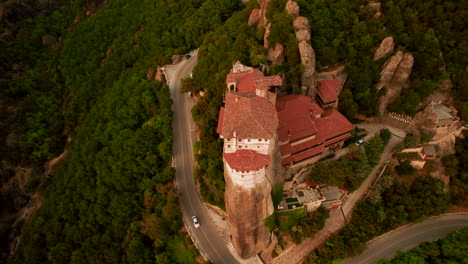 drone tilt down view of greek monastery perched atop rock column