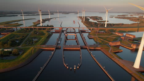 aerial view of canal lock with wind turbines at sunset