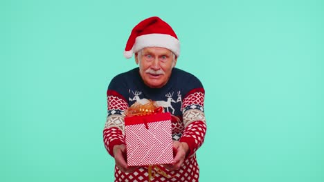 Senior-grandfather-man-wears-New-Year-sweater-presenting-Christmas-gift-box,-shopping-sale-holidays