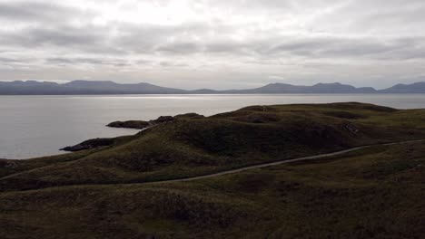 Vista-Aérea-De-La-Isla-De-Ynys-Llanddwyn,-Sendero-Costero-De-Anglesey-Con-Montañas-De-Snowdonia-A-Través-Del-Mar-De-Irlanda,-Dolly-Adelante