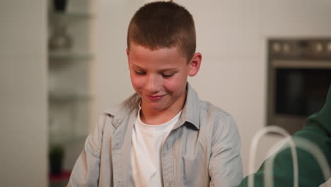 hungry schoolboy takes cookies from mom smiling contentedly