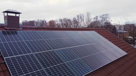 Sonnenkollektoren-Für-Erneuerbare-Energien-In-Blauer-Farbe-Auf-Privatem-Dach,-Luftbild