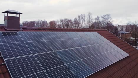 Blue-color-renewable-energy-solar-panels-on-private-rooftop,-aerial-view