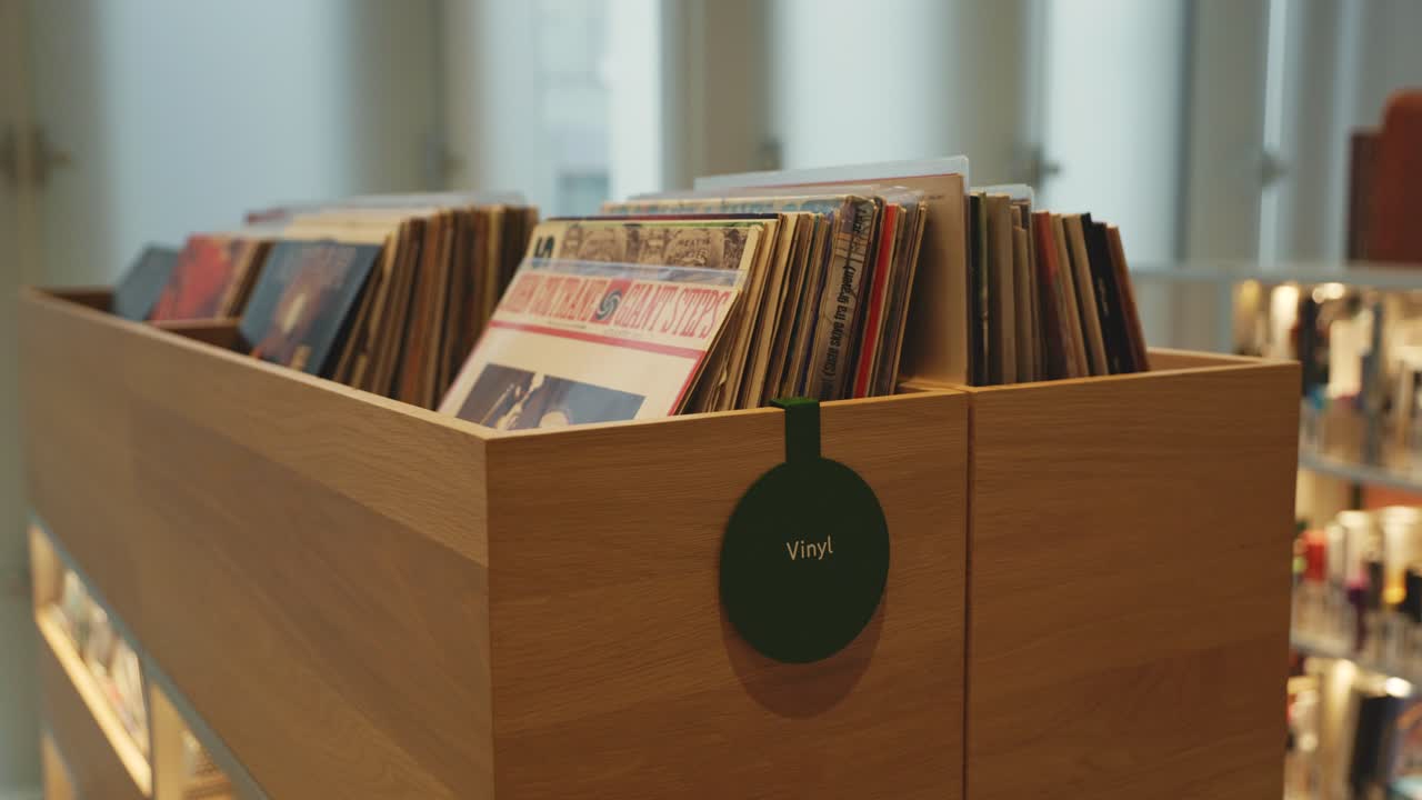 A wooden box filled with vinyl records, offering a nostalgic and artistic touch to the library setting.
