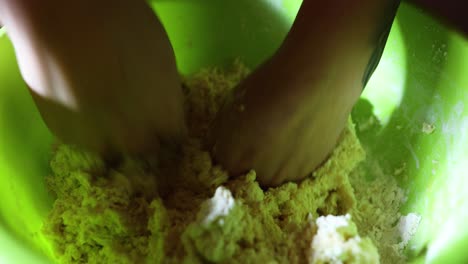 Cook-Mixing-The-Dough-In-A-Plastic-Bowl---high-angle,-close-up